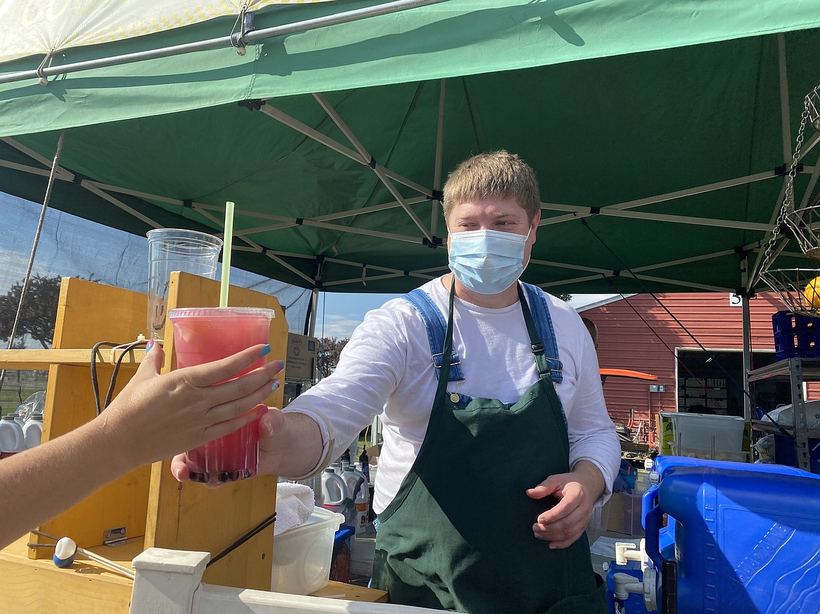 Steven Kunz of Old Fashion County Kettle Corn passes out a refreshing huckleberry lemonade at the North Idaho State Food Fair Fix event Friday evening. (MADISON HARDY/Press)