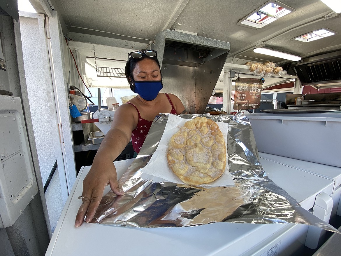 Christine White, owner of White's Concessions, serves up her fan-favorite elephant ears at the North Idaho State Fair Food Fix Friday evening. (MADISON HARDY/Press)