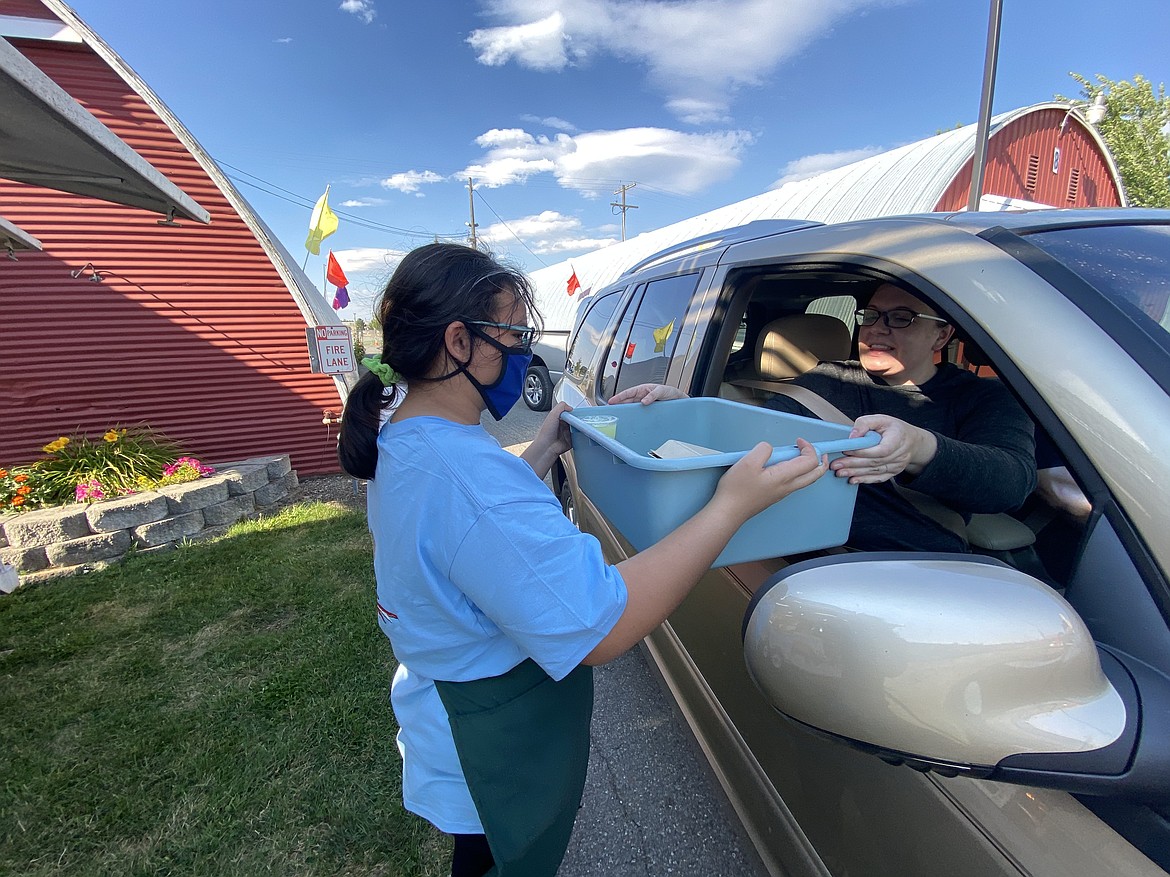 White's Concessions hands out Jolene Compton's order at the drive-thru Fair Food Fix event at the Kootenai County Fairgrounds Friday evening. (MADISON HARDY/Press)