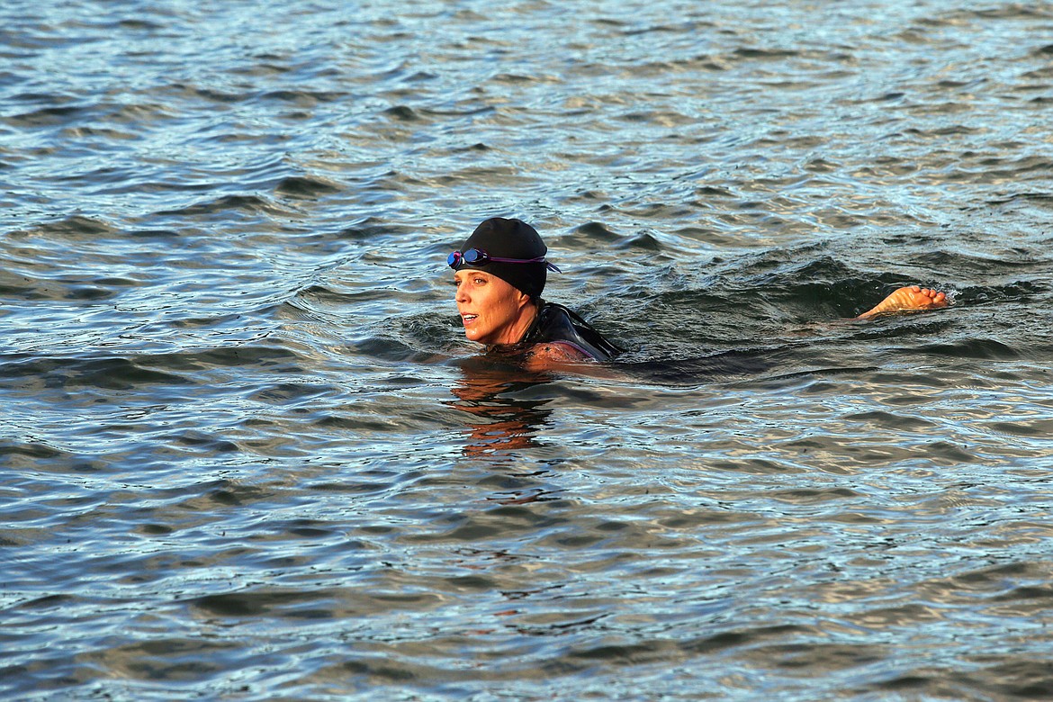 Jen Hays completes the final stretch of the swim in Lake Coeur d’Alene on Saturday as part of a triathlon with her training group from Peak Health and Wellness.