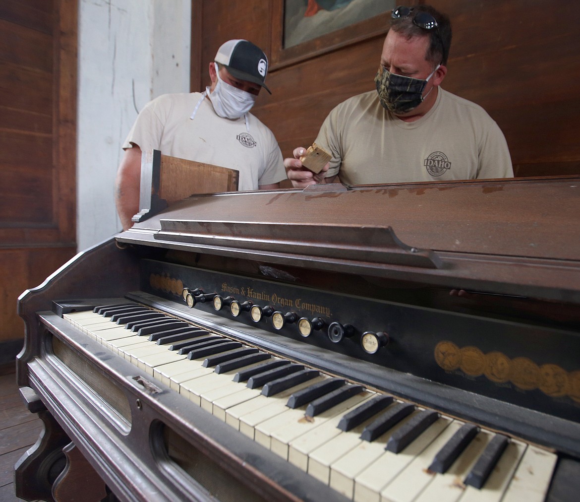 BILL BULEY/Press 
 Chris Nash, left, and Lanny Neipert inspect the 1878 organ in the Mission of the Sacred Heart and at Old Mission State Park on Monday.