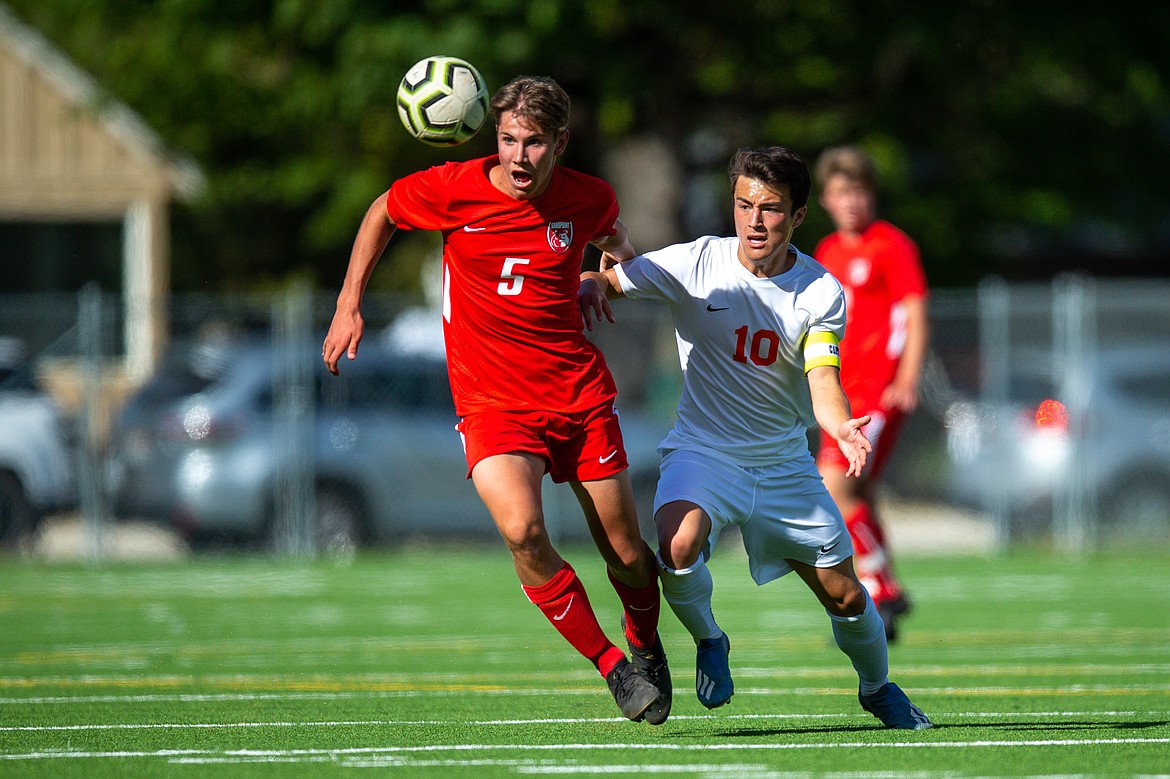 (Photo courtesy of JASON DUCHOW PHOTOGRAPHY) 
 Junior Evan Darling heads the ball in the midfield while fighting off a Post Falls defender on Tuesday at War Memorial Field.