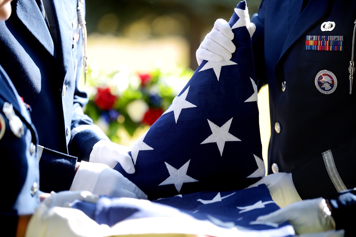 Members of the Malmstrom Air Force Base Honor Guard carefully fold the flag that will be presented to the family at the funeral of Neil Van Sickle on Tuesday afternoon, October 22, in C.E. Conrad Memorial Cemetery in Kalispell. Staff Sgt. Joshua Crist presented the flag to Kathleen Leatham, on of Maj. Gen. Van Sickle's daughters. 
 (Brenda Ahearn/Daily Inter Lake)