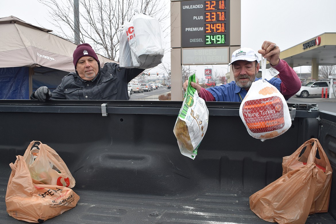Charles H. Featherstone/Columbia Basin Herald 
 Steve Dahl, a pharmacist with the Moses Lake Community Health Center, and Bill Cooper, a maintenance technician with Samaritan Health Care, load groceries and frozen turkeys into the back of a truck in the Safeway parking lot of Friday as part of the annual Turkey Drive led by Samaritan, Confluence Health Care, and the Moses Lake Community Health Care Center.