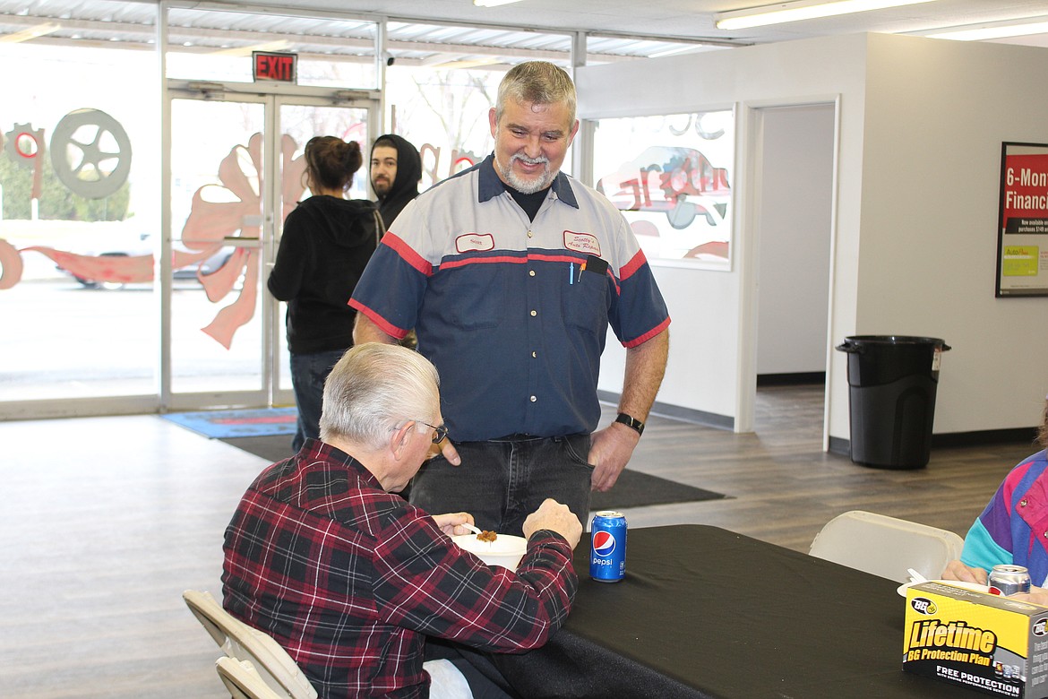 Scott Myers (standing), owner of Scotty’s Auto Repair, talks with a customer during the grand opening at his new location Thursday.