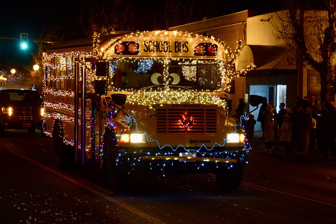 An Ephrata school bus decked out with lights slowly drives down Basin Street on Saturday as part of the town’s Miracle on Main Street Parade.