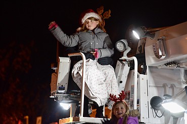 Two girls wave from the back of a PUD truck during Ephrata’s Miracle on Main Street Parade on Saturday.