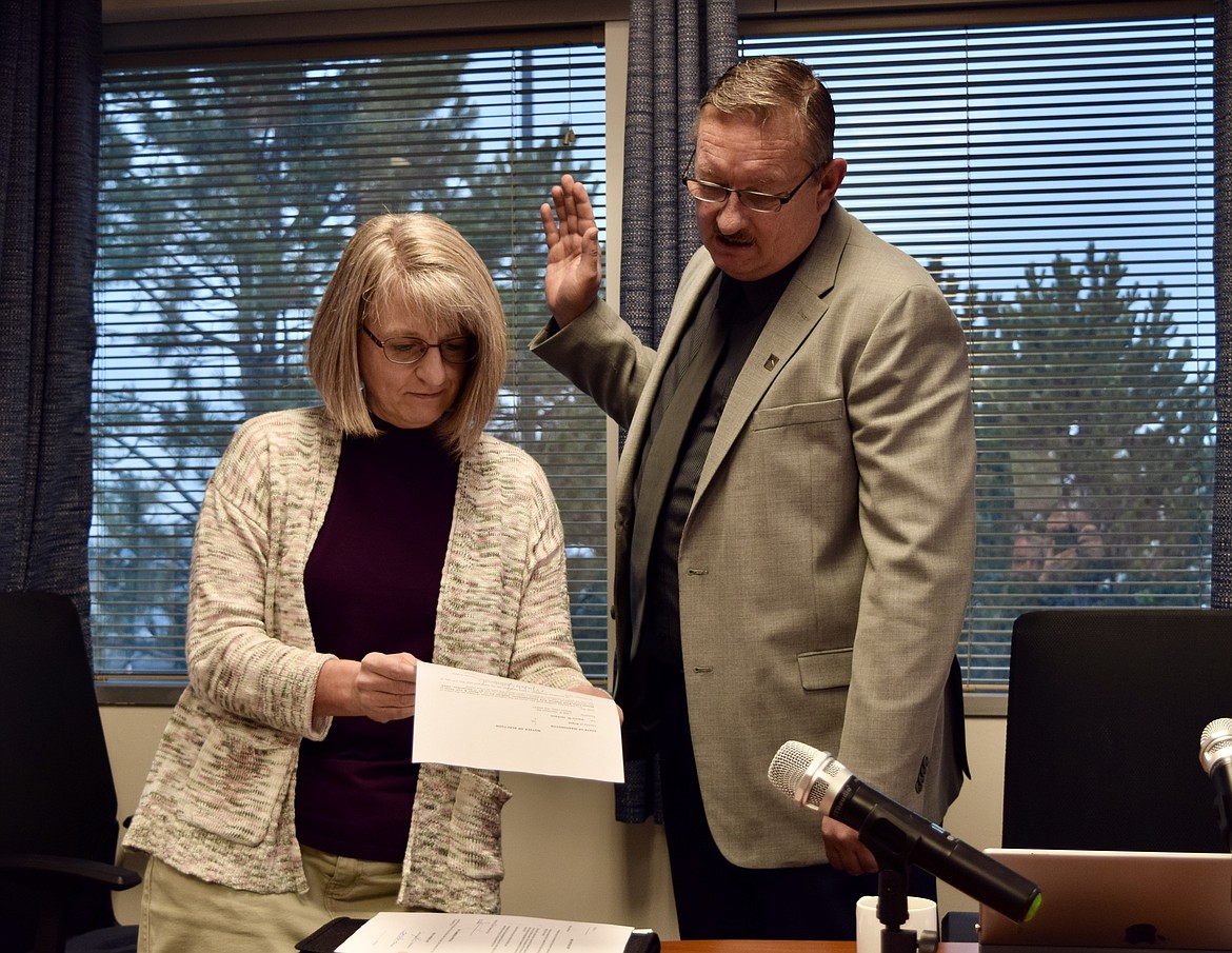 Kim DeTrolio swears in Darrin Jackson to his first full term as Port of Moses Lake commissioner on Monday. Jackson was named to fill a vacancy on the port commission several years ago, and ran unopposed for a full term in November.
