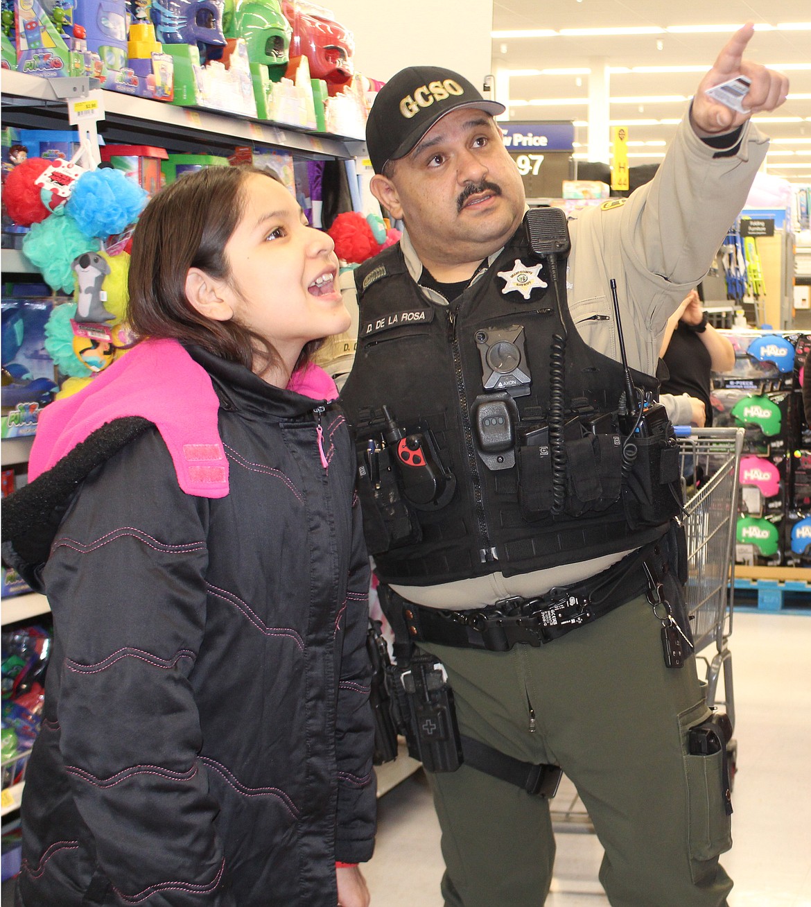 Delia Miranda and her shopping buddy Dave DeLaRosa of the Grant County Sheriff’s Office look over the options in the doll aisle during the eighth annual ‘Shop with a Cop’ Wednesday.