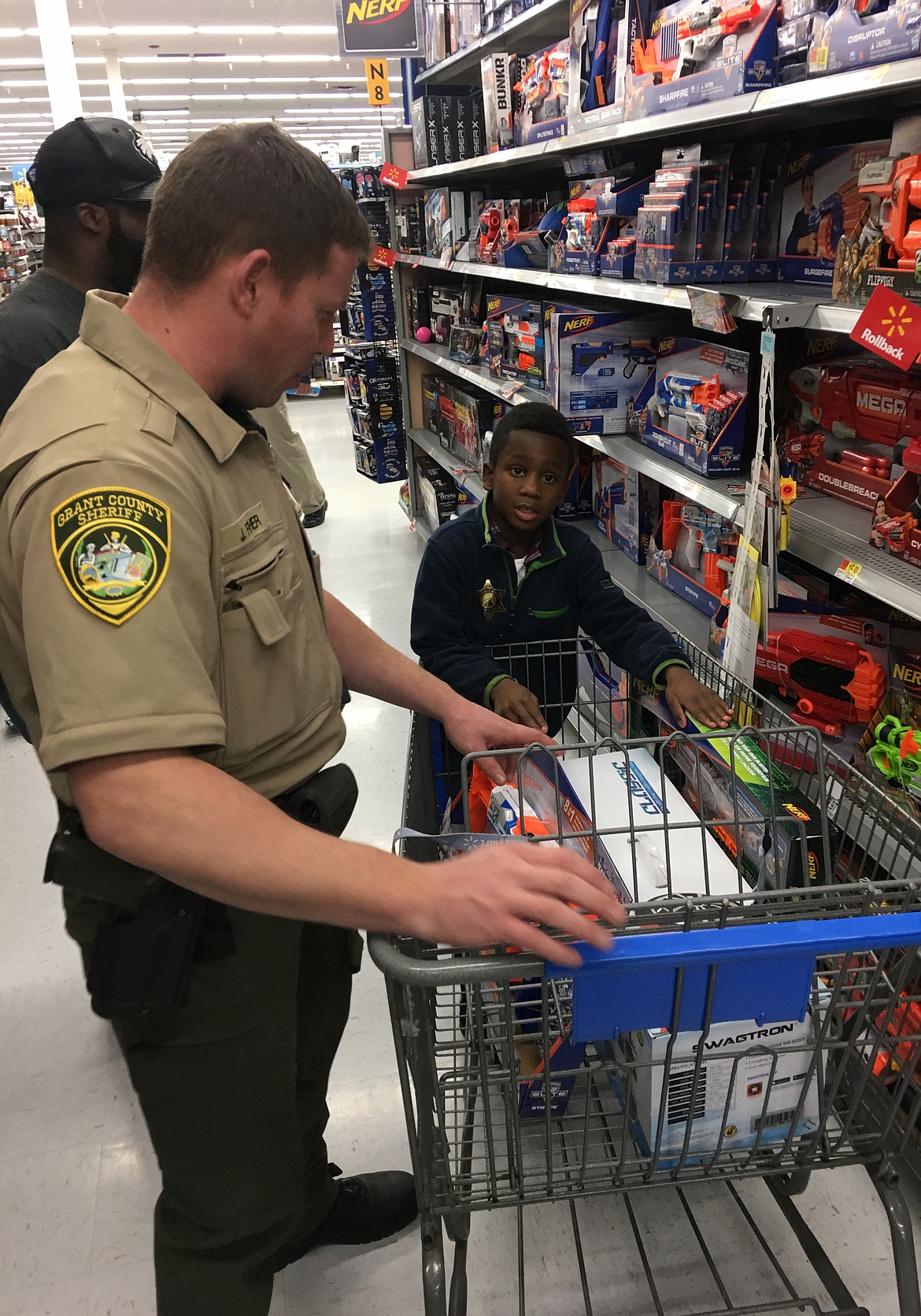 Grant County Sheriff’s Deputy Jake Fisher discusses the finer points of Nerf weaponry with 7-year-old Ocie Richie of Moses Lake at last year’s Shop with a Cop event.