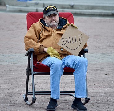 A man who would only give his name as Sid sits in Sinkiuse Square in downtown Moses Lake Friday afternoon urging on some holiday cheer. ‘I just like to see people smile,’ he said.