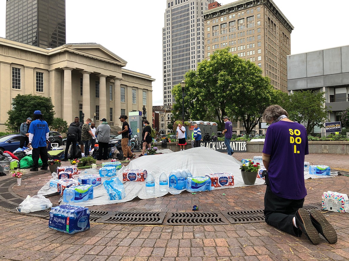 ADDS ID OF MAN PRAYING - John Kriner, of Jeffersonville, Ind., prays at Jefferson Square Park on Sunday, June 28, 2020, in Louisville, Ky., which has been the site of weeks of protests. Authorities were investigating a fatal shooting Saturday night at the park in downtown Louisville where demonstrators had gathered to protest the death of Breonna Taylor. (AP Photo/Dylan Lovan)