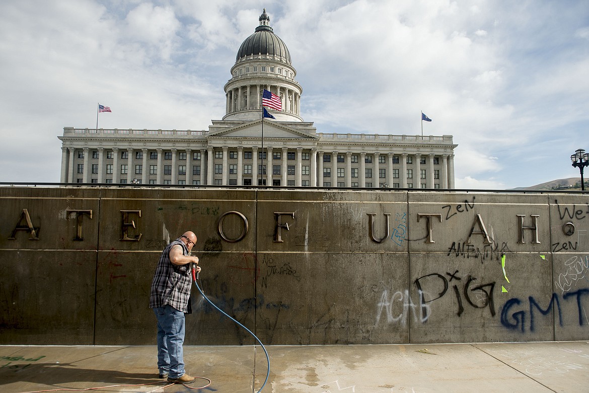 Don Gamble cleans up graffiti at the Capitol in Salt Lake City on Sunday, May 31, 2020, following protests over the death of George Floyd. Protests were held throughout the country over the death of Floyd, a black man who died after being restrained by Minneapolis police officers on May 25.   (Jeremy Harmon/The Salt Lake Tribune via AP)