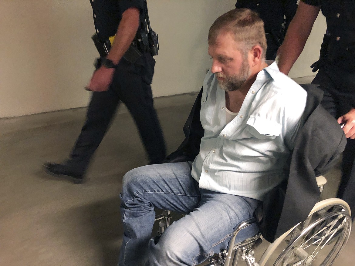 Anti-government activist Ammon Bundy is wheeled from the Idaho Statehouse in Boise, Idaho, on Wednesday, Aug. 26, 2020, following his second arrest for trespassing in two days. Bundy was arrested Tuesday in a committee room and charged with trespassing. (AP Photo/Keith Ridler)