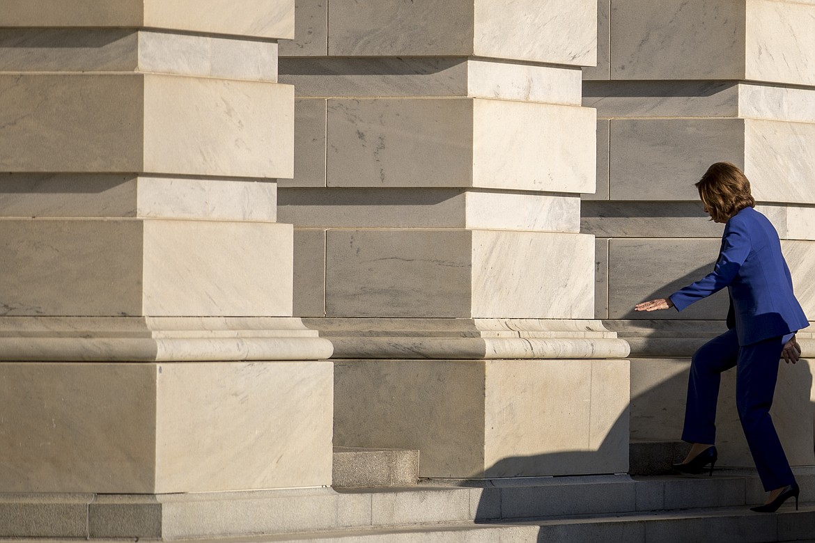 House Speaker Nancy Pelosi of Calif. arrives as the House prepares to debate emergency coronavirus response legislation on Capitol Hill, Friday, March 27, 2020, in Washington. (AP Photo/Andrew Harnik)
