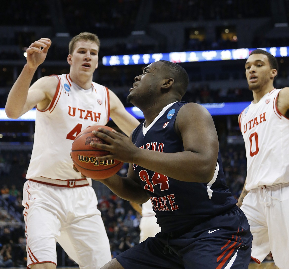 Fresno State center Terrell Carter II, front, goes up for a shot as Utah forwards Jakob Poeltl, back left, and Brekkott Chapman defend in the first half of a first-round men's college basketball game Thursday, March 17, 2016, in the NCAA Tournament in Denver. (AP Photo/Brennan Linsley)