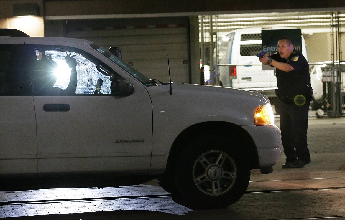 FILE - In this Thursday, July 7, 2016 file photo, a police officer stops a driver in downtown Dallas after police officers were shot and killed during a protest over fatal police shootings of black men in other states. Ambushes and targeted attacks on police officers in the U.S. claimed at least 20 lives. The victims included five officers in Dallas working to keep the peace at a protest over the fatal police shootings of black men in Minnesota and Louisiana. Ten days after that attack, a man killed three officers in Baton Rouge, Louisiana. In Iowa, two policemen were fatally shot in separate ambush-style attacks while sitting in their patrol cars. (AP Photo/LM Otero)