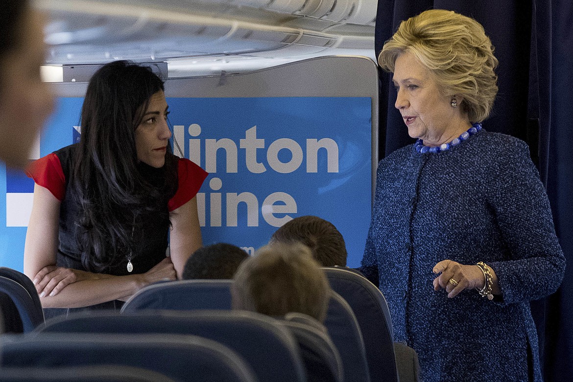 FILE - In this Oct. 28, 2016 file photo, Democratic presidential candidate Hillary Clinton speaks with senior aide Huma Abedin aboard her campaign plane at Westchester County Airport in White Plains. Amid the 2016 presidential campaign, the FBI conducted an investigation into Clinton's use of a private computer server to handle emails she sent and received as secretary of state. FBI Director James Comey criticized Clinton for carelessness but said the bureau would not recommend criminal charges.  (AP Photo/Andrew Harnik, File)