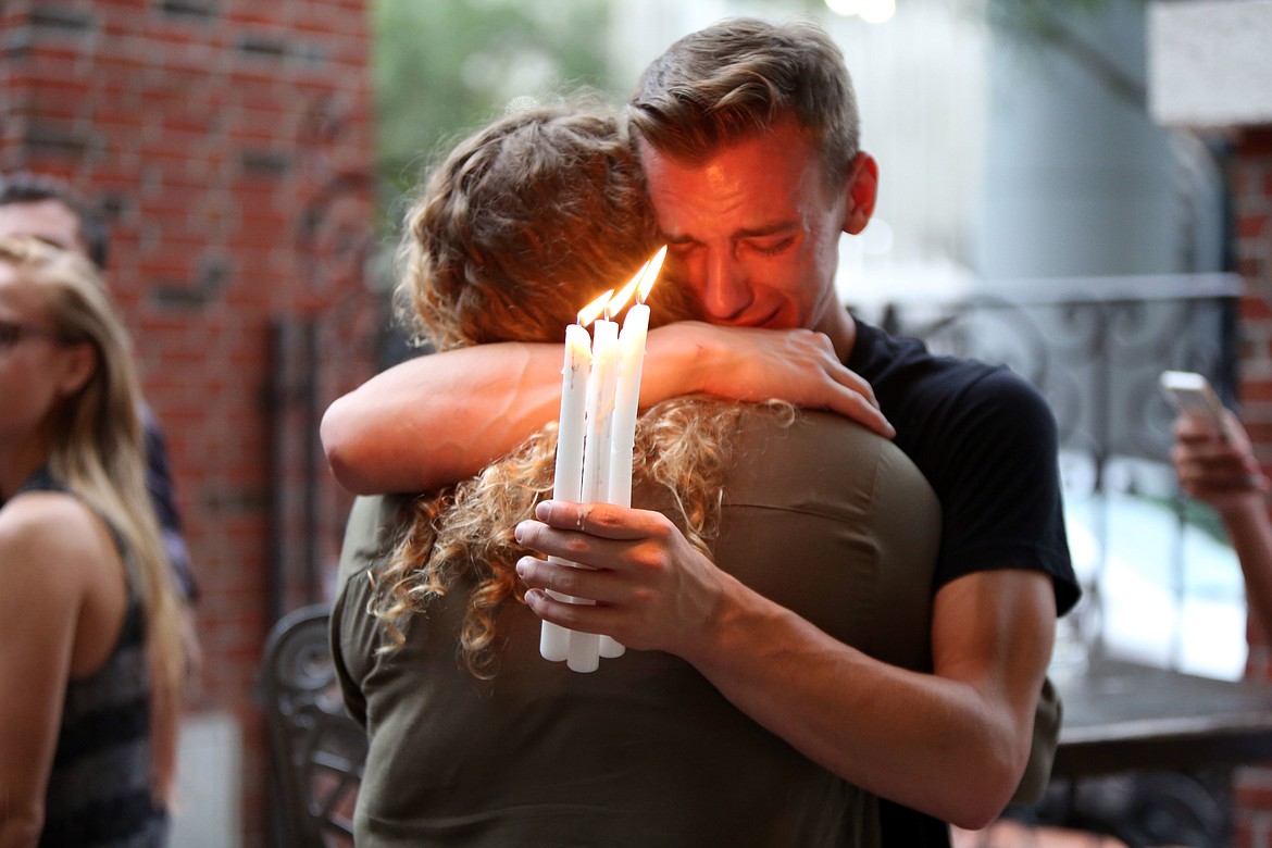 FILE - In this Sunday, June 12, 2016 file photo, Brett Morian hugs an fellow mourner during a candlelight vigil for those killed at the Pulse nightclub in Orlando, Fla. The worst mass shooting in modern U.S. history unfolded on Latin Night at the gay nightclub. The gunman, Omar Mateen, killed 49 people over the course of three hours before dying in a shootout with SWAT team members. During the standoff, he pledged allegiance to the Islamic State. (Joshua Lim/Orlando Sentinel via AP)