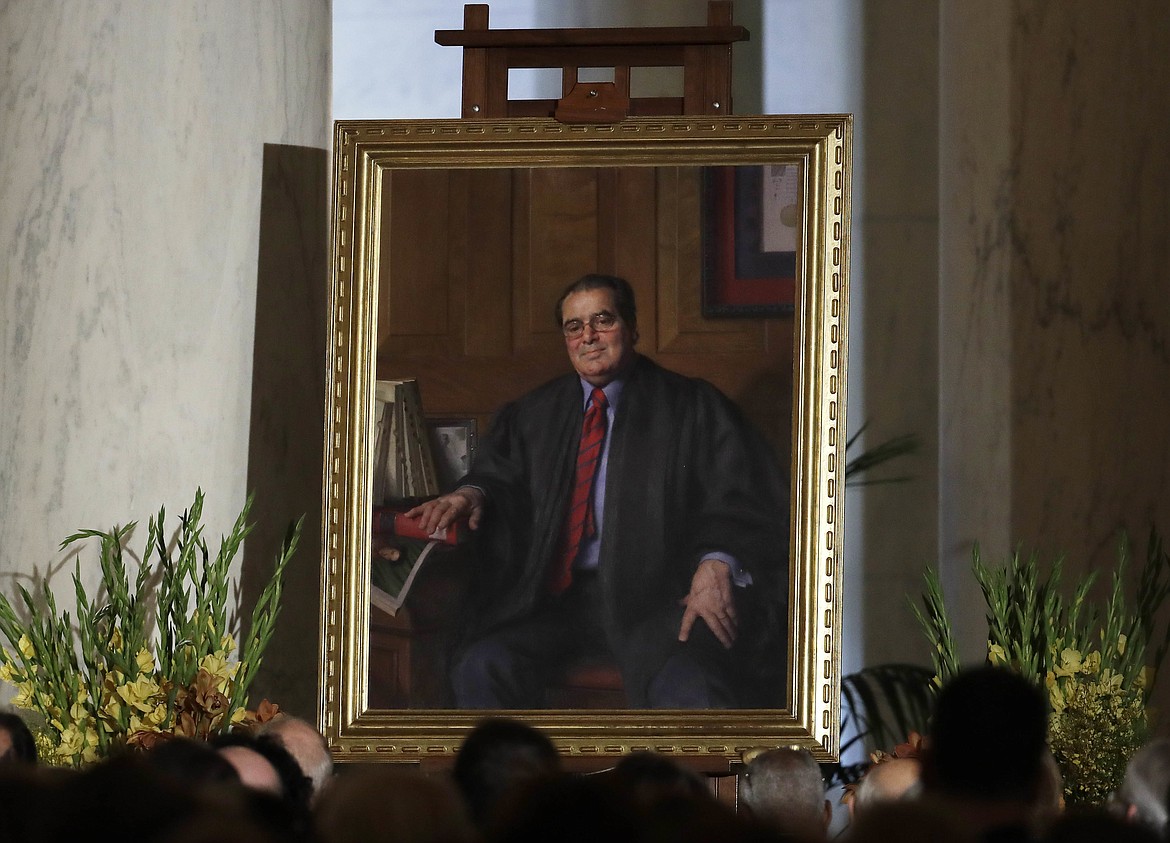 FILE - In this Friday, Nov. 4, 2016 file photo, a portrait of the late Supreme Court Justice Antonin Scalia is displayed during a memorial for him held in the Great Hall of the Supreme Court building in Washington. After Scalia's death in February 2016, President Barack Obama nominated Merrick Garland, chief judge of the U.S. Court of Appeals, to fill the vacancy. However, majority Republicans in the Senate refused to consider the nomination, opting to leave the seat vacant so it could be filled by the winner of the presidential election. Donald Trump has promised to appoint a conservative in the mold of Scalia. (AP Photo/Carolyn Kaster, Pool)