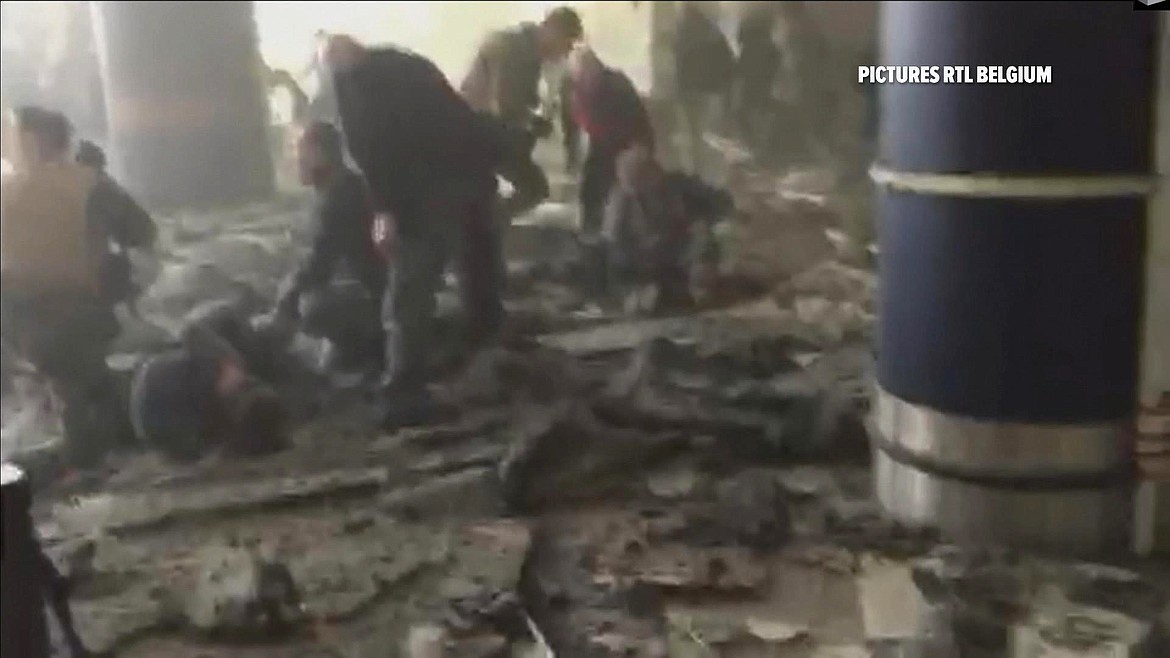 FILE - In this Tuesday, March 22, 2016 image made from video provided by RTL Belgium, people receive treatment in the debris-strewn terminal at Brussels Airport after a series of explosions. Across the globe, terrorist attacks flared at a relentless pace throughout the year. Among the many high-profile attacks were those that targeted airports in Brussels and Istanbul, a park teeming with families and children in Pakistan, and the seafront boulevard in Nice, France, where 86 people were killed when a truck plowed through a Bastille Day celebration. In Iraq alone, many hundreds of civilians were killed in repeated bombings. (RTL via AP)