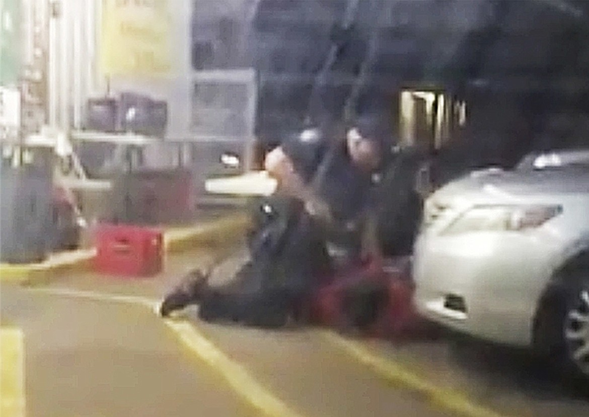 FILE - In this Tuesday, July 5, 2016 image made from video, Alton Sterling is restrained by two Baton Rouge police officers, one holding a gun, outside a convenience store in Baton Rouge, La. Moments later, one of the officers shot and killed Sterling, a black man who had been selling CDs outside the store, while he was on the ground. A day later, a white police officer shot and killed Philando Castile during a traffic stop in a suburb of Minneapolis. Coming after several similar cases in recent years, the killings rekindled debate over policing practices and the Black Lives Matter movement. (Arthur Reed via AP)