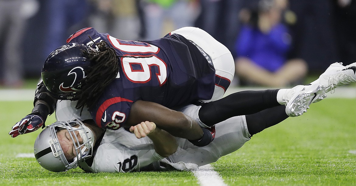 Oakland Raiders quarterback Connor Cook (8) is hit by Houston Texans defensive end Jadeveon Clowney (90) during the second half of an AFC Wild Card NFL football game Saturday, Jan. 7, 2017, in Houston. (AP Photo/Eric Gay)