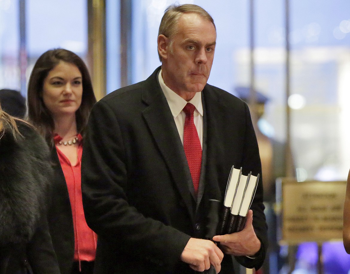 FILE - In this Dec. 12, 2016, file photo, Interior Secretary-designate Rep. Ryan Zinke, right, R-Mont., arrives in Trump Tower, in New York, Monday, Dec. 12, 2016. Zinke says he would never sell, give away or transfer public lands, a crucial stance in his home state of Montana and the West, where access to hunting and fishing is considered sacrosanct. (AP Photo/Richard Drew, File)