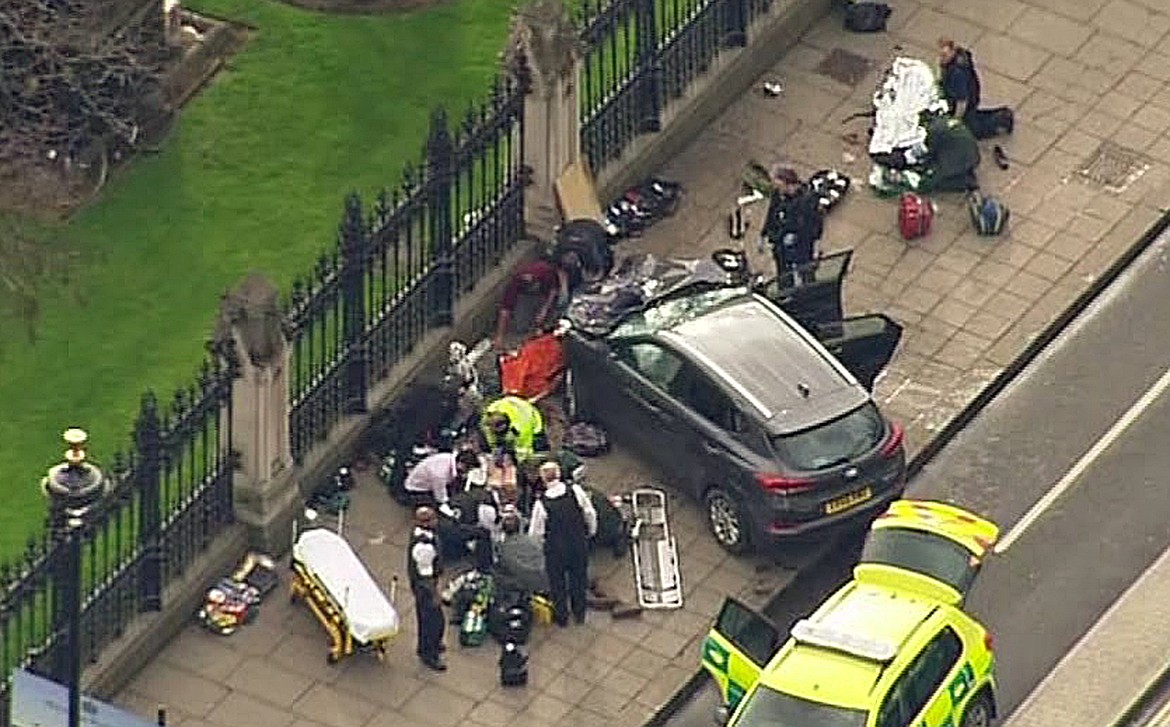 In this image taken from video police officers gather around a car adjacent to Houses of Parliament in London, Wednesday, March 23, 2017 after the House of Commons sitting was suspended as witnesses reported sounds like gunfire outside. The leader of Britain&#146;s House of Commons says a man has been shot by police at Parliament. David Liddington also said there were &#147;reports of further violent incidents in the vicinity.&#148; (ITN via AP)