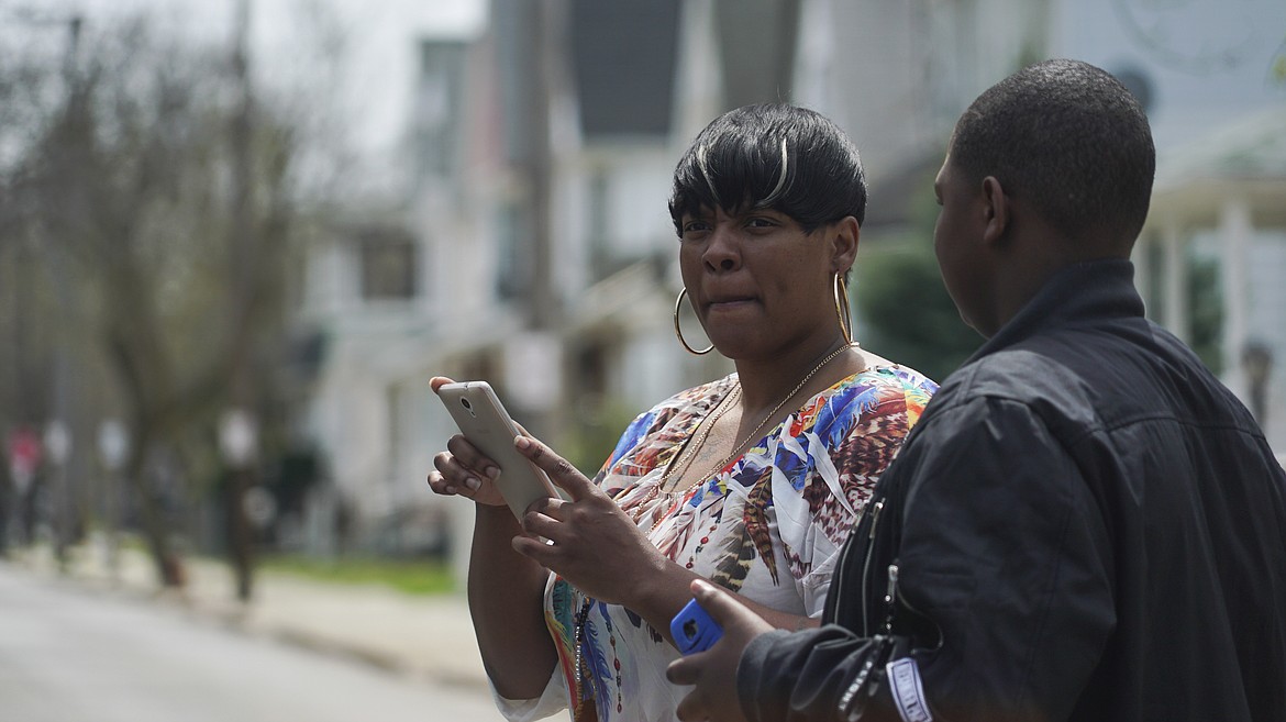 Alexis Lee, a childhood friend of Steve Stephens, speaks with a neighbor near Stephens' childhood home in Cleveland, Ohio, Monday, April 17, 2017. Authorities in Cleveland have expanded their manhunt nationwide for Stephens, a man suspected of gunning down a retiree and posting a video of the crime on Facebook. (AP Photo/Dake Kang)