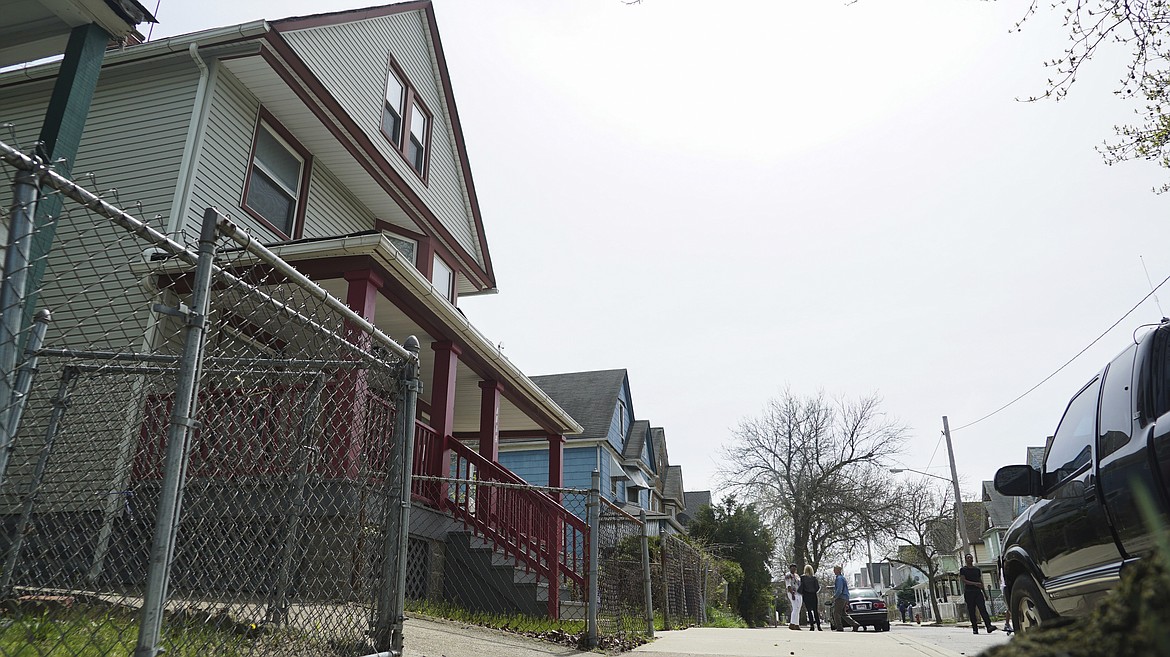 Steve Stephens' childhood home, left, is shown as neighbors chat down the street in Cleveland, Ohio, Monday, April 17, 2017. Authorities in Cleveland have expanded their manhunt nationwide for Stephens, a man suspected of gunning down a retiree and posting a video of the crime on Facebook. (AP Photo/Dake Kang)