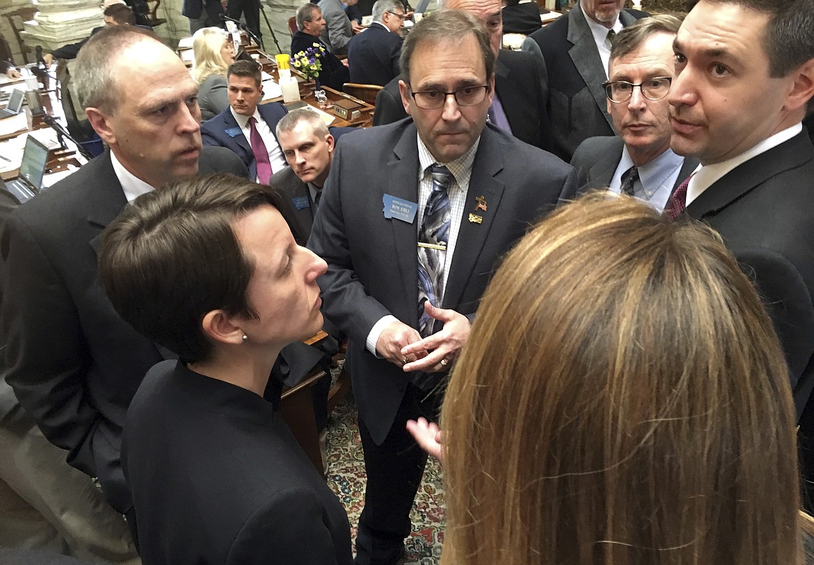 Legislative leaders confer on the House floor of the Montana Capitol in Helena, Mont., on Friday, April 28, 2017, during a tumultuous final legislative day. House Speaker Austin Knudsen, R-Culbertson, far right, and House Minority Leader Jenny Eck, D-Helena, bottom left, led the showdown between Republicans and Democrats over a contentious infrastructure bonding bill, which failed to pass the House. (AP Photo/Bobby Caina Calvan)