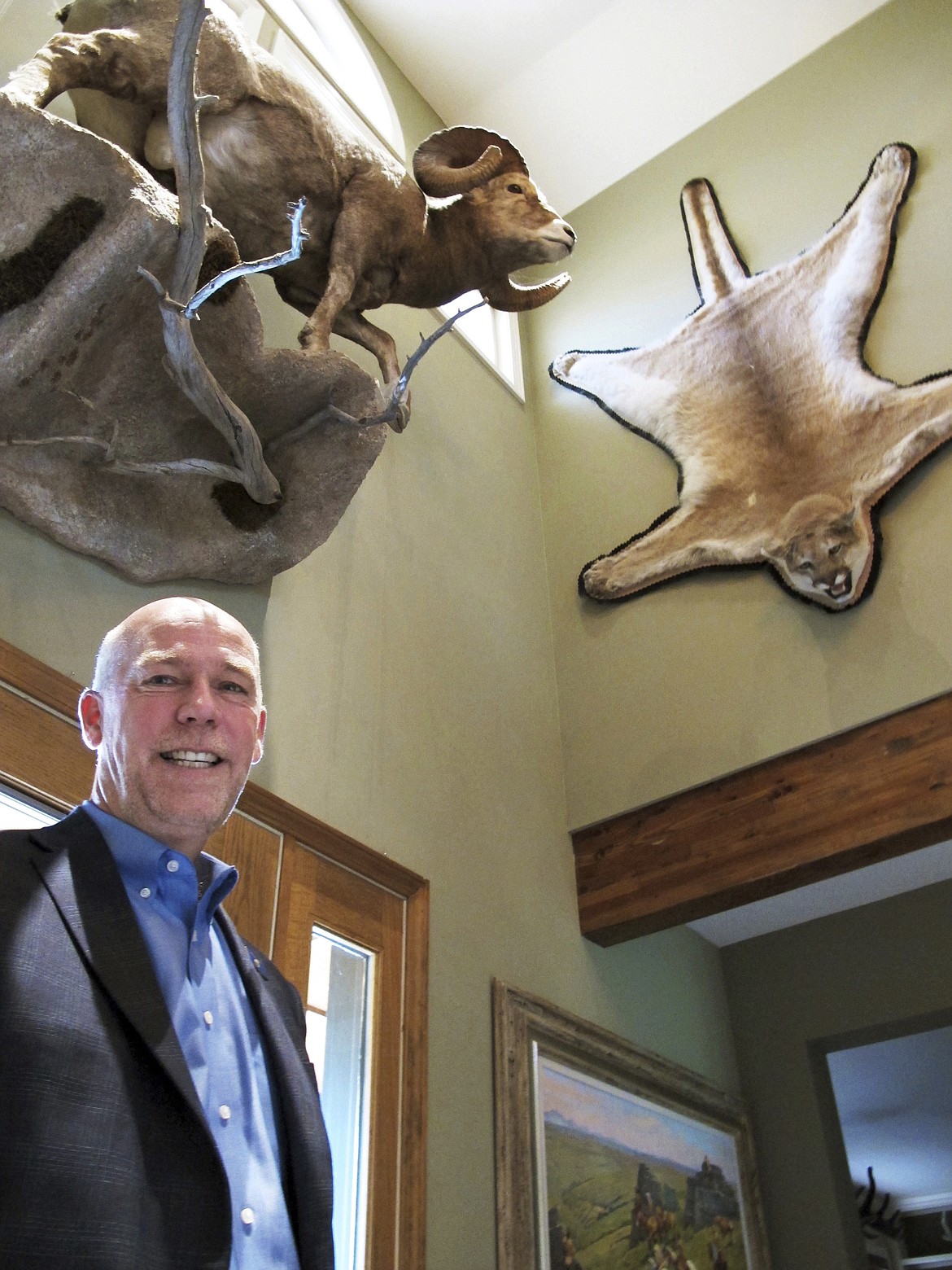 FILE - In this Oct. 5, 2016 file photo, gubernatorial candidate, Republican Greg Gianforte poses below animal trophies in his home in Bozeman, Mont. Donald Trump Jr. will be targeting more than Republican voters when the president's son campaigns for U.S. House candidate Greg Gianforte in Montana on Friday, April 21, 2017 and Saturday, leading to backlash from at least one animal-rights organization. Gianforte, who is up against Democrat Rob Quist in the May 25 election for the U.S. House seat vacated by Interior Secretary Ryan Zinke, is planning to take Trump on a prairie dog hunt during their four-city campaign tour. (AP Photo/Matt Volz, File)