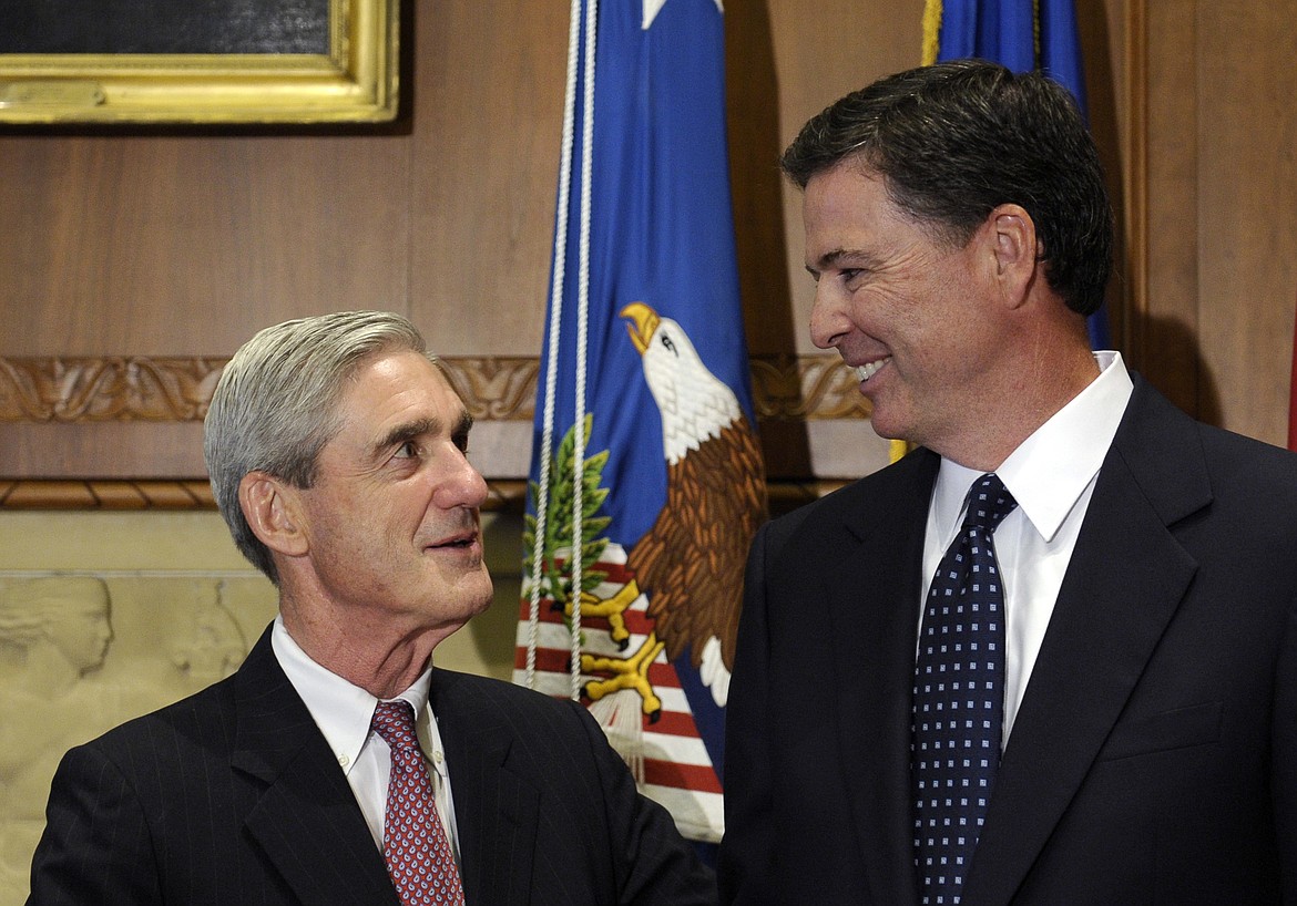 FILE - In this Sept. 4, 2013, file photo, then-incoming FBI Director James Comey talks with outgoing FBI Director Robert Mueller before Comey was officially sworn in at the Justice Department in Washington.  On May 17, 2017, the Justice Department said is appointing Mueller as special counsel to oversee investigation into Russian interference in the 2016 presidential election. (AP Photo/Susan Walsh, File)