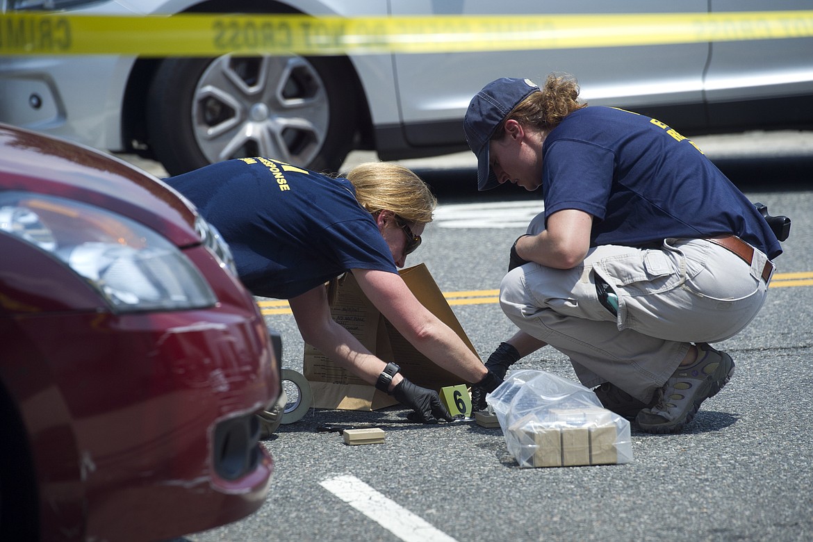 FBI Evidence Response Team members mark evidence at the scene of a multiple shooting in Alexandria, Va., Wednesday, June 14, 2017, involving House Majority Whip Steve Scalise of La., and others during a congressional baseball practice. (AP Photo/Cliff Owen)