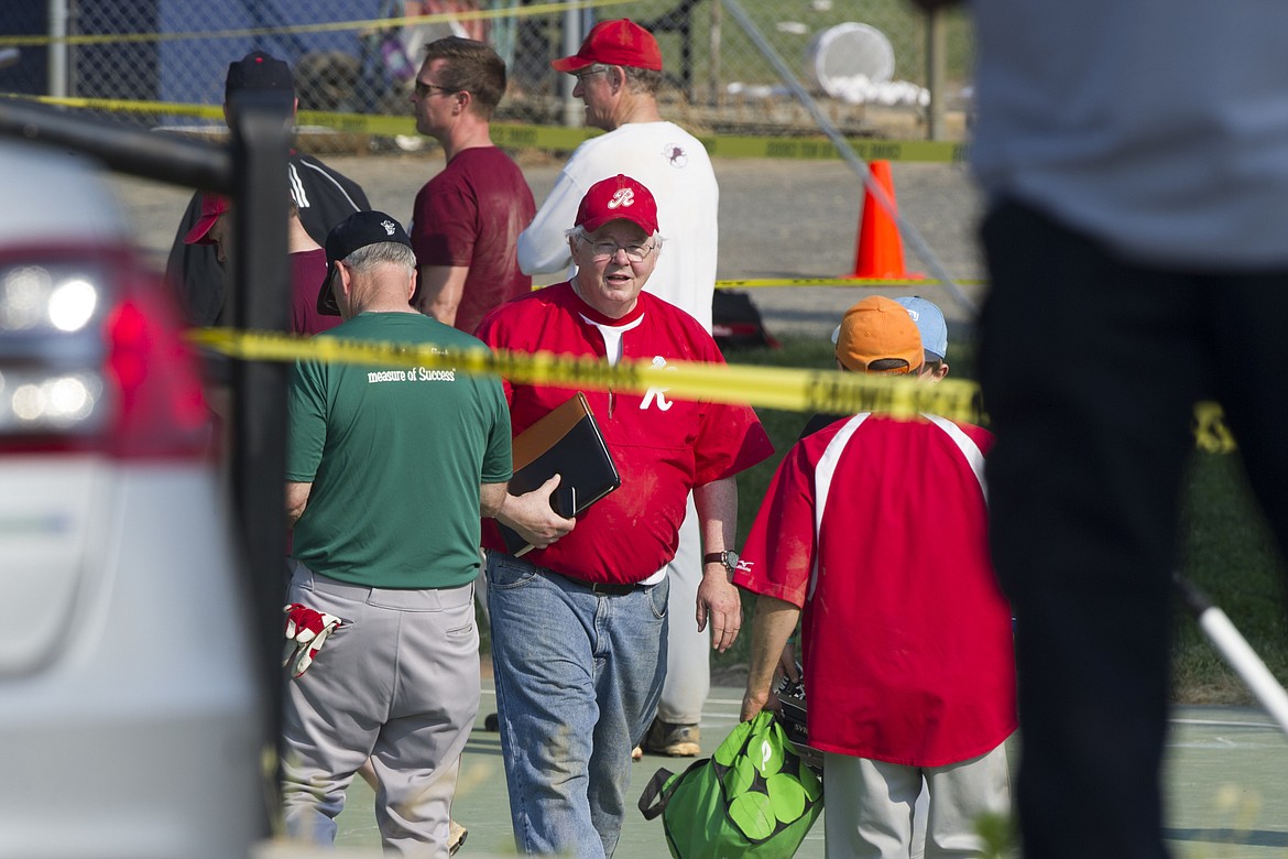 Rep. Joe Barton, R-Texas, center, and other members of the Republican Congressional softball team, stand behind police tape of the scene of a multiple shooting in Alexandria, Va., Wednesday, June 14, 2017, where House Majority Whip Steve Scalise of La. was shot. (AP Photo/Cliff Owen)