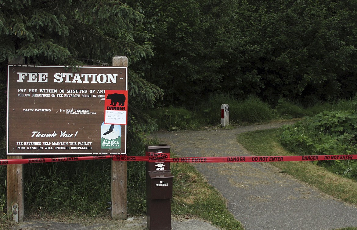 A sign warns people that the trail head is closed on Monday, June 19, 2017, after a fatal bear mauling at Bird Ridge Trail in Anchorage, Alaska. Authorities say a black bear killed a 16-year-old runner while he was competing in an Alaska race on Sunday. (AP Photo/Mark Thiessen)