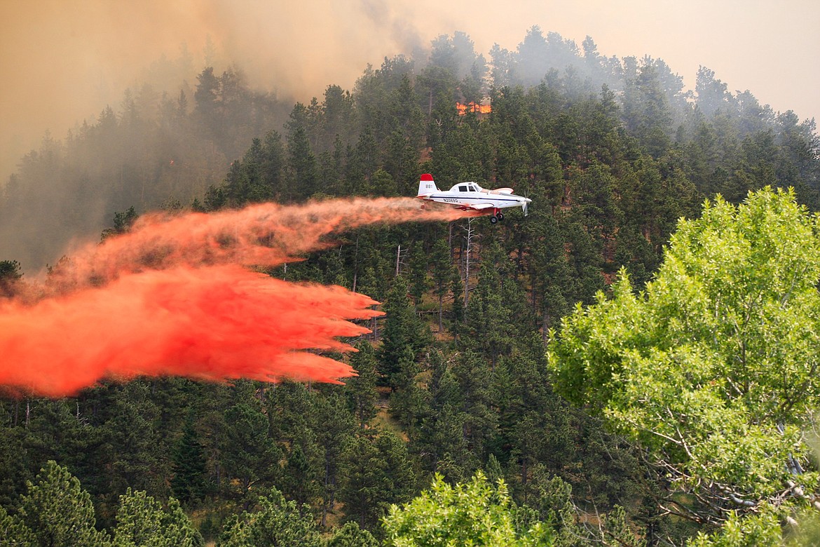 A plane drops retardant on a wildfire near the historic mining town of Landusky, south of the Fort Belknap Indian Reservation in north-central Montana on July 6. (Meg Oliphant/The Billings Gazette via AP)