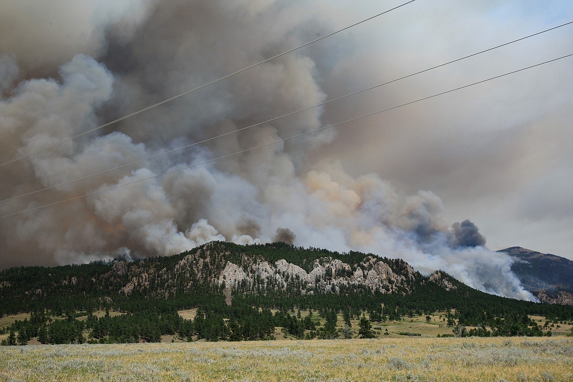 In this Thursday, July 6, 2017, a wildfire burns near the historic mining town of Landusky, south of the Fort Belknap Indian Reservation in north-central Montana. Officials ordered about 30 residents to evacuate after winds shifted and the wildfire moved to within a mile of the historic mining town. (Meg Oliphant/The Billings Gazette via AP)