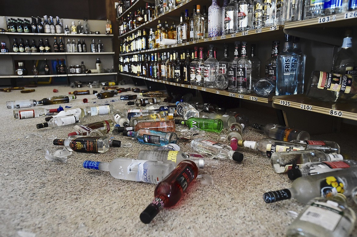 Liquor bottles that rattled off the shelves after an earthquake sit on the floor at a liquor store Thursday in Lincoln. (Thom Bridge/Independent Record via AP)