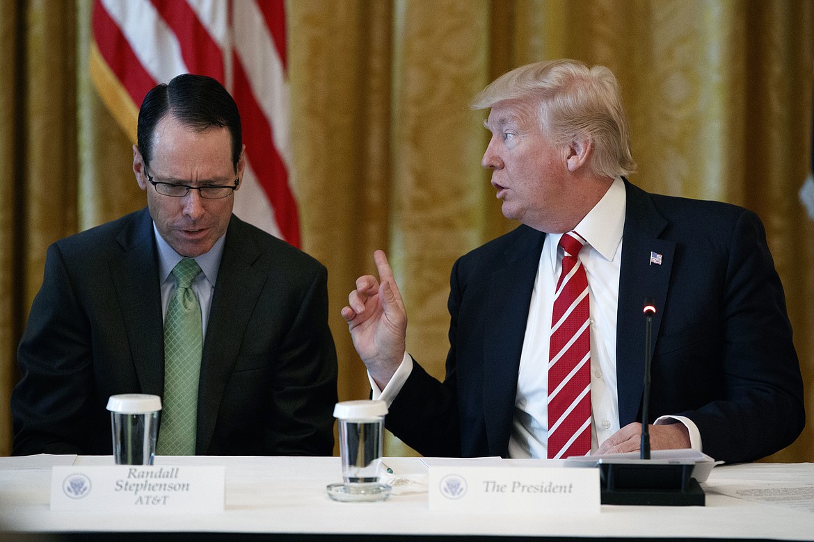 FILE- In this June 22, 2017, file photo, AT&amp;T CEO Randall Stephenson, left, listens as President Donald Trump speaks during the &quot;American Leadership in Emerging Technology&quot; event in the East Room of the White House in Washington. Boy Scouts president Randall Stephenson told The Associated Press on Wednesday, July 26, in his first public comments on the furor over President Donald Trump's speech at the 2017 National Boy Scout Jamboree on Monday that he'd be &quot;disingenuous&quot; if he suggested he was surprised by the Republican president's comments. (AP Photo/Evan Vucci, File)