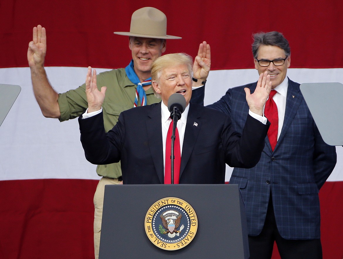 FILE- In this Monday, July 24, 2017, file photo, President DonaldTrump, front left, gestures as former boys scouts, Interior Secretary Ryan Zinke, left, Energy Secretary Rick Perry, watch at the 2017 National Boy Scout Jamboree at the Summit in Glen Jean, W.Va. Boy Scouts president Randall Stephenson told The Associated Press on Wednesday, July 26, in his first public comments on the furor over President Donald Trump's speech on Monday that he'd be &quot;disingenuous&quot; if he suggested he was surprised by the Republican president's comments. (AP Photo/Steve Helber, File)
