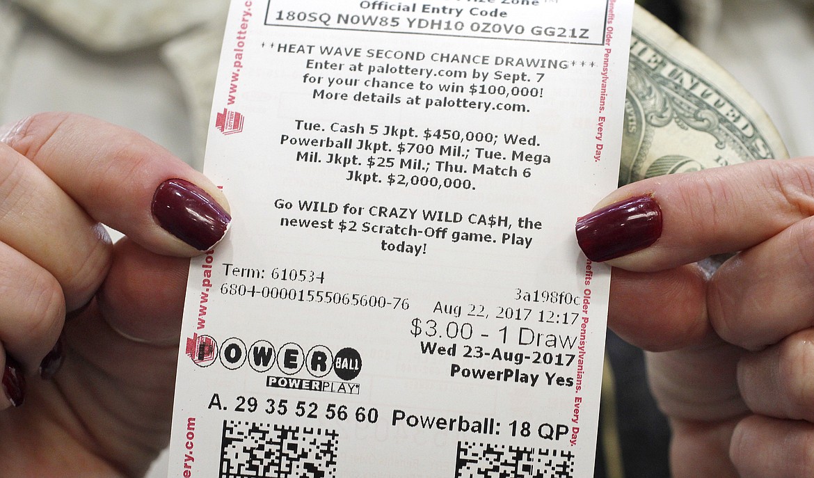 Jackie Haaf, 58, of Erie, Pa., shows off her Powerball ticket at a convenience store in Summit Township, Pa., on Tuesday, Aug. 22, 2017. (Christopher Millette/Erie Times-News via AP)