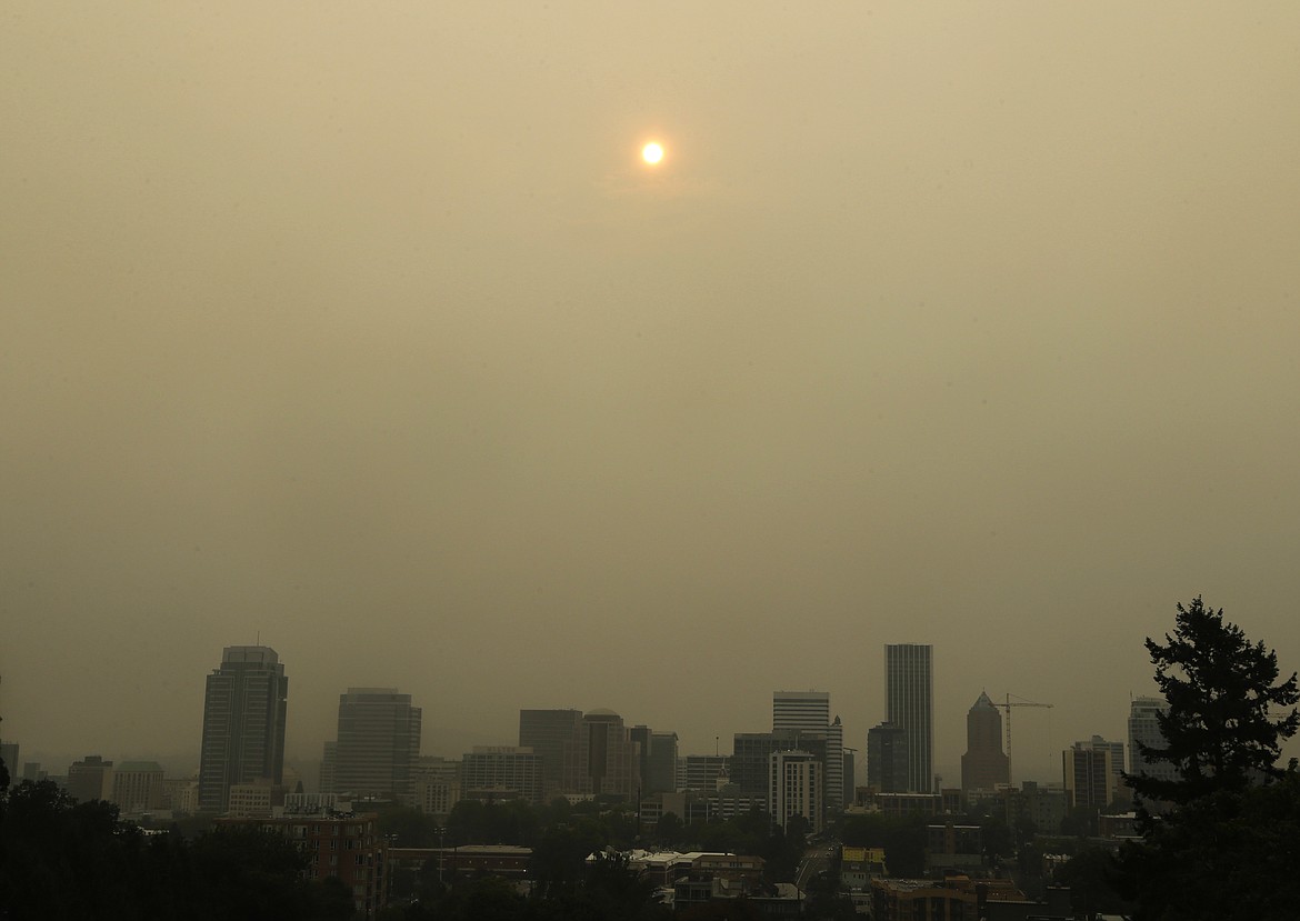 The sun is barely visible over downtown Portland, Ore., Wednesday, Sept. 6, 2017, as seen through smoke from wildfires burning in the Columbia River Gorge east of Portland.  The growing blaze east of Portland, Oregon, in the scenic Columbia River Gorge, was one of dozens of wildfires burning in western U.S. states that sent smoke into cities from Seattle to Denver.  (AP Photo/Don Ryan)