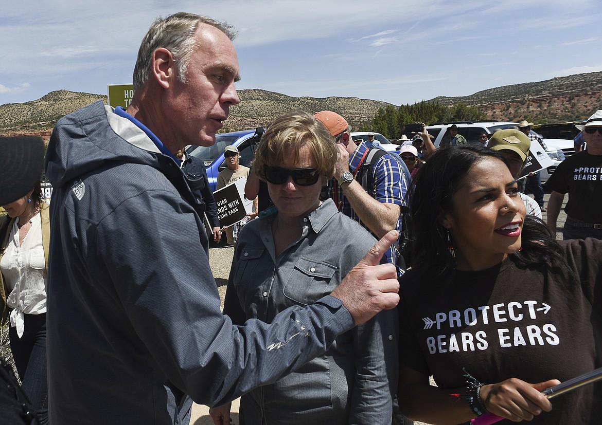 FILE--In this May 8, 2017, file photo, Interior Secretary Ryan Zinke argues with pro monument activist Cassandra Begay after she directed pointed questions regarding his failure to meet with more Native Americans during his tour of Bears Ears National Monument in southeastern Utah. Zinke has closely followed his boss&#146; playbook, encouraging mining and drilling on public lands and size reductions for national monuments that President Donald Trump said were part of a &#147;massive land grab.&#148; Yet Zinke&#146;s made an exception in his home state of Montana. (Francisco Kjolseth/The Salt Lake Tribune via AP, file)