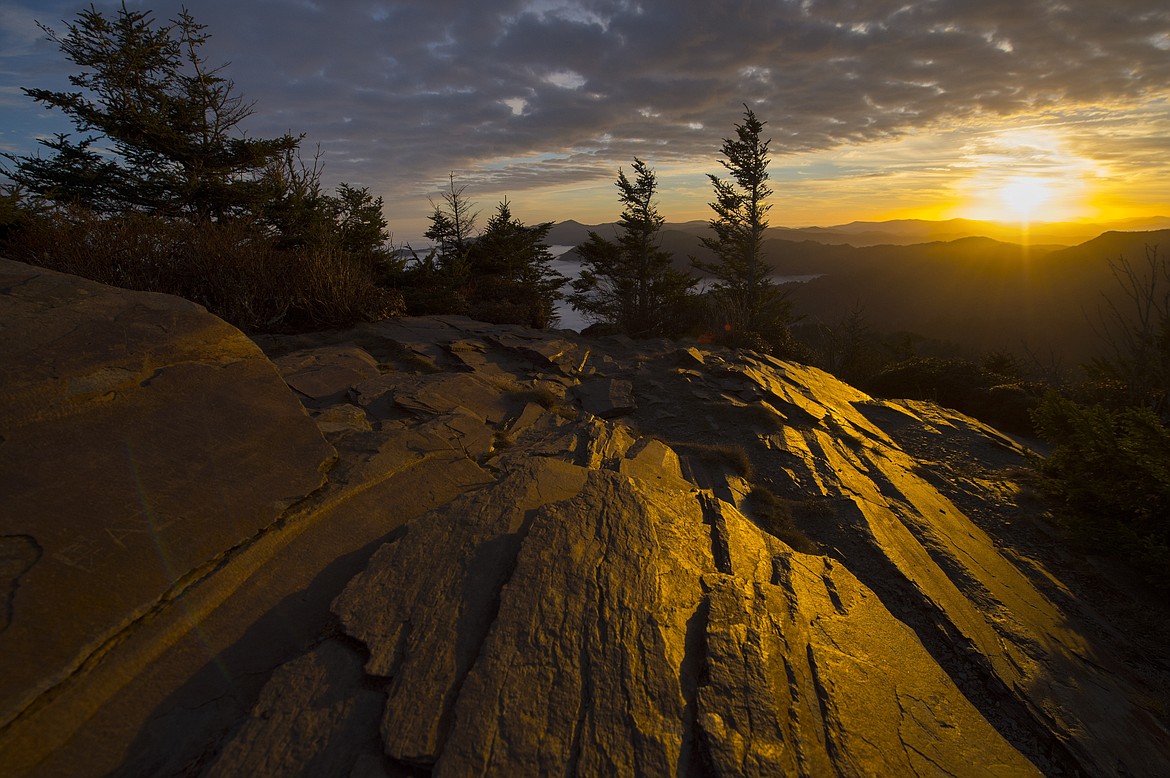 FILE - In this Nov. 13, 2014 file photo, the sunrise illuminates rocks at Myrtle Point on Mt. LeConte in the Great Smoky Mountains National Park near Galtinburg, Tenn. Hawaii residents and an organization representing federal workers filed a lawsuit against the Federal Aviation Administration on Wednesday, Oct. 4, 2017 seeking to force it to do something about tour helicopters buzzing around seven national parks across the country. (AP Photo/Knoxville News Sentinel, Adam Lau, File)