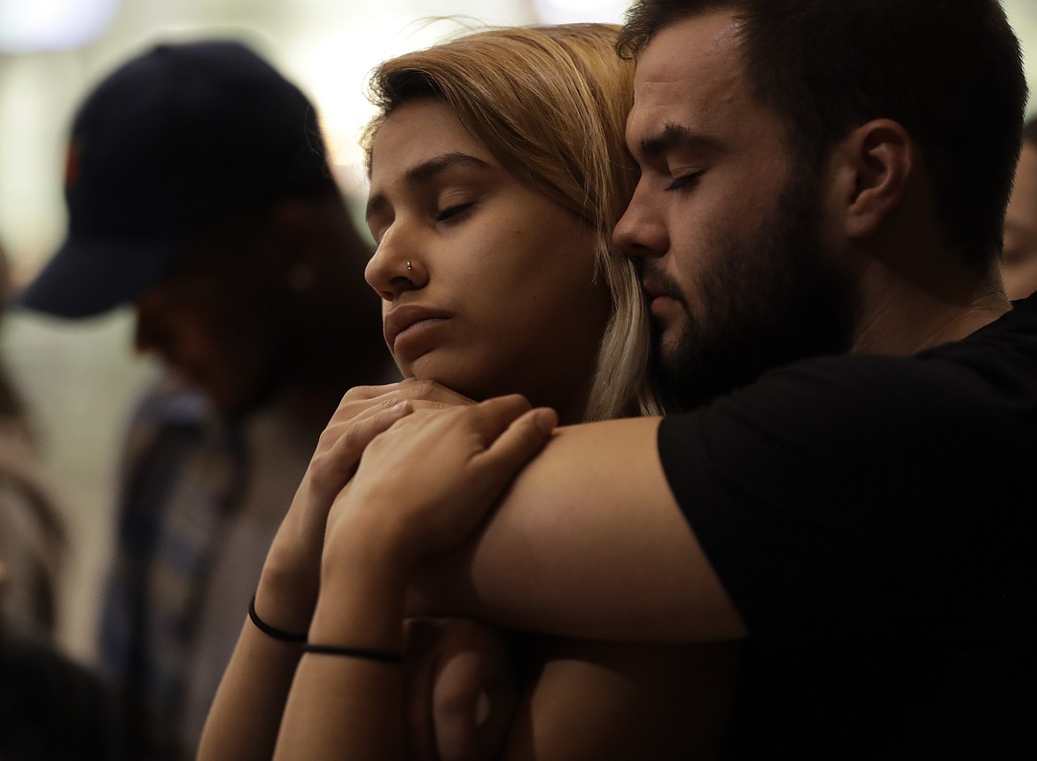 University of Nevada Las Vegas students Raymond Lloyd, right, and Karla Rodriguez take part in a vigil Monday, Oct. 2, 2017, in Las Vegas. A gunman on the 32nd floor of the Mandalay Bay casino hotel rained automatic weapons fire down on the crowd of over 22,000 at an outdoor country music festival Sunday. (AP Photo/Gregory Bull)