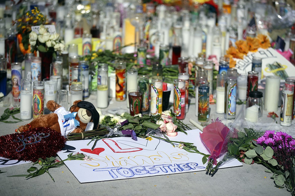 Flowers, candles and toys are left at a makeshift memorial site on Las Vegas Boulevard on Tuesday, Oct. 3, 2017, in Las Vegas. A gunman opened fire on an outdoor music concert on Sunday killing dozens and injuring hundreds. (AP Photo/Chris Carlson)