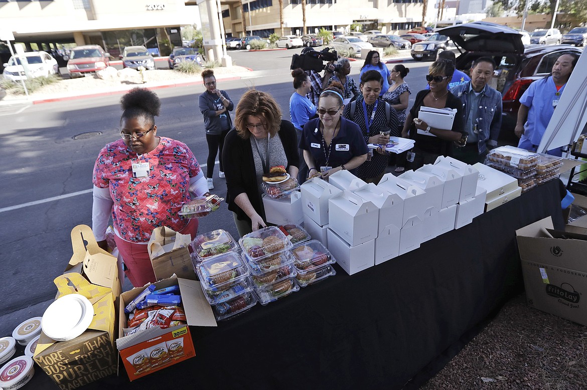 Healthcare workers from UMC Hospital in Las Vegas, get free food on Tuesday, Oct. 3, 2017. A gunman opened fire on an outdoor music concert on Sunday, with over 50 people killed and hundreds injured. (AP Photo/Gregory Bull)