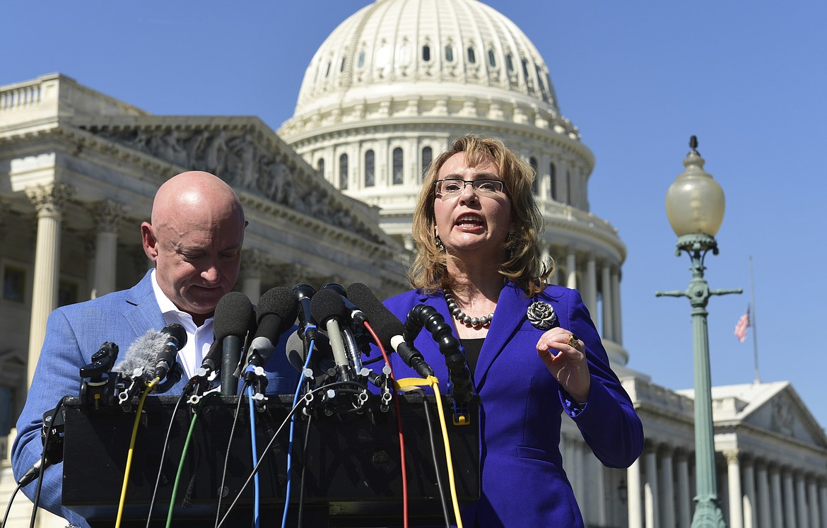 Former Rep. Gabrielle Giffords, D-Ariz., right, standing with her husband Mark Kelly, left, speaks on Capitol Hill in Washington, Monday, Oct. 2, 2017, about the mass shooting in Las Vegas. Giffords, was a congresswoman when she was shot in an assassination attempt in 2011. (AP Photo/Susan Walsh)